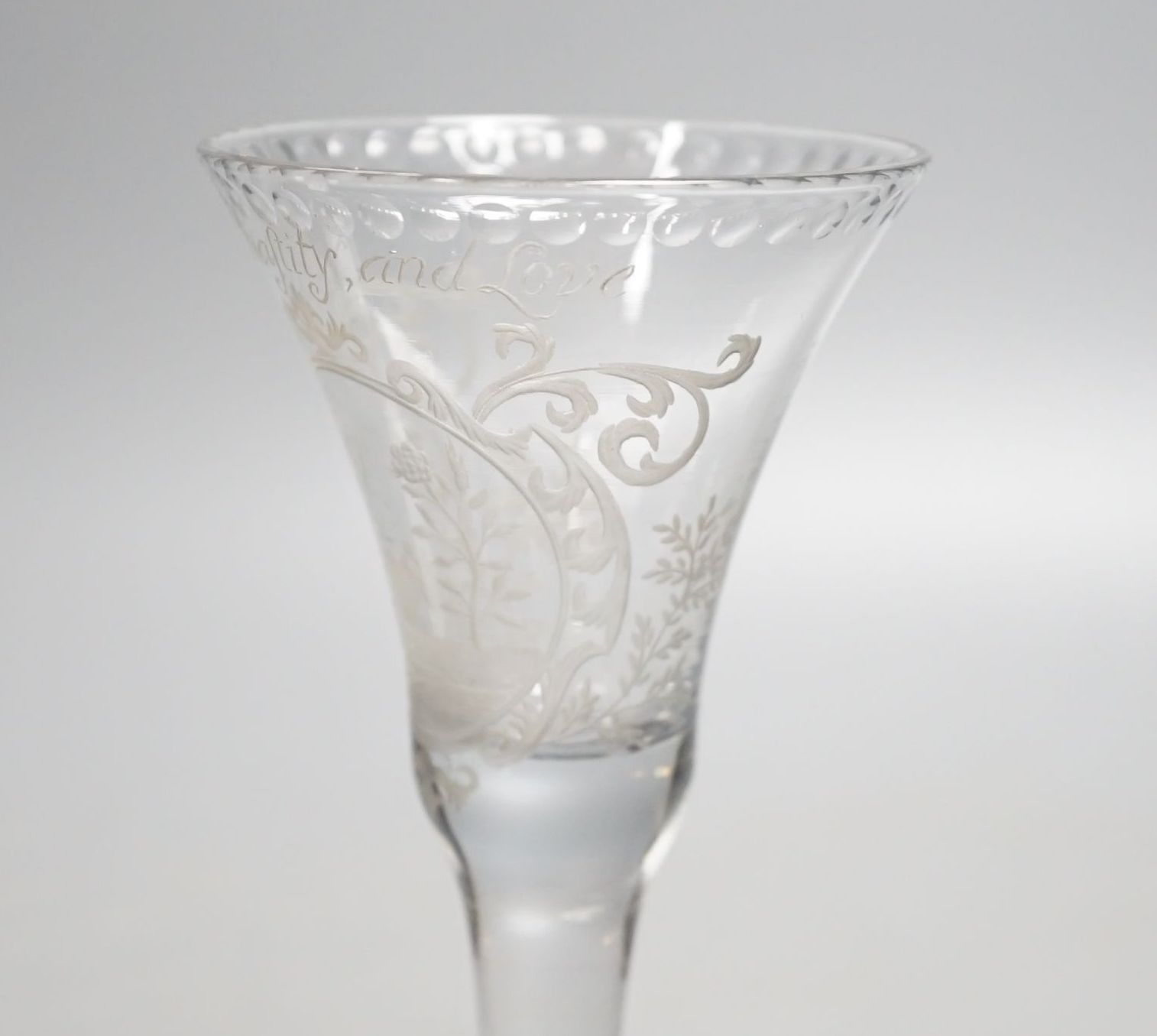 A Georgian wine glass, possibly later engraved ‘Beauty, Chastity, and Love above a lily, heart and rose. 16cm